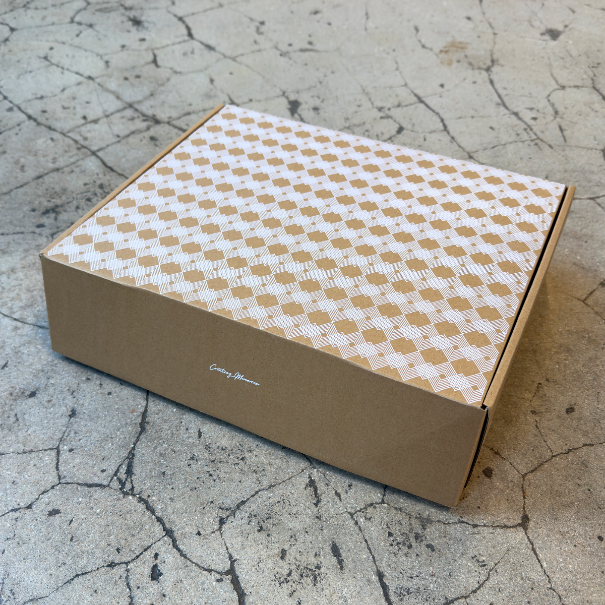 Brun stängd kartong med vitt mönster tryckt. mot stenfärgad bakgrund